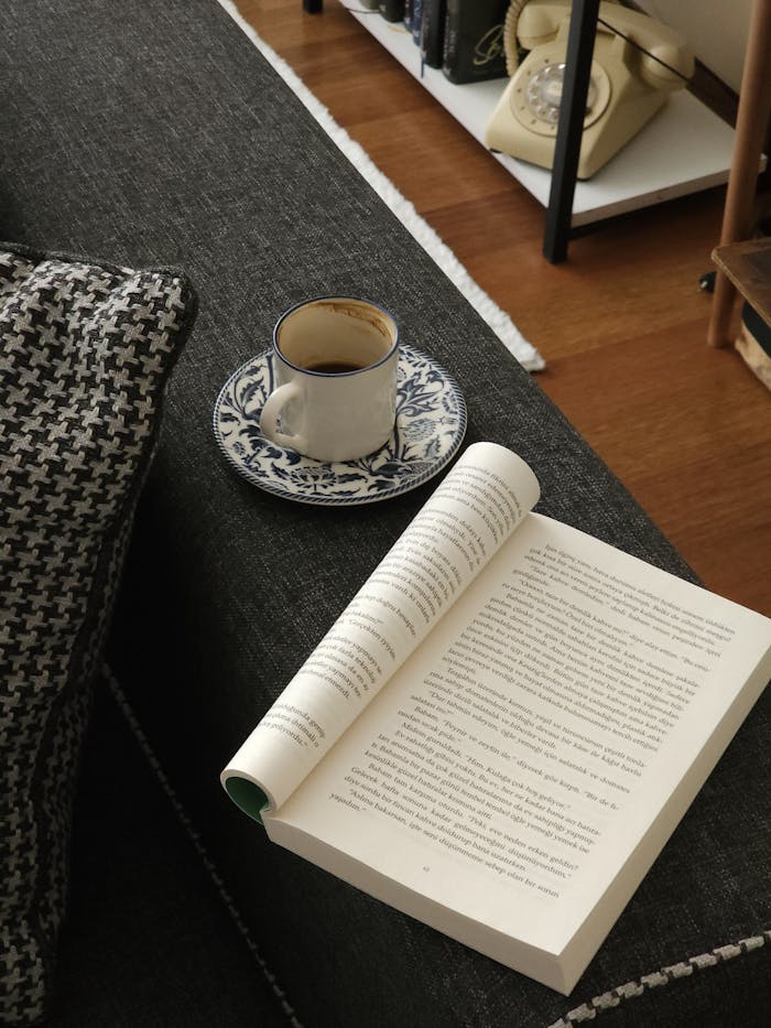 An inviting setup with a book and coffee on a couch. Ideal for relaxing at home.