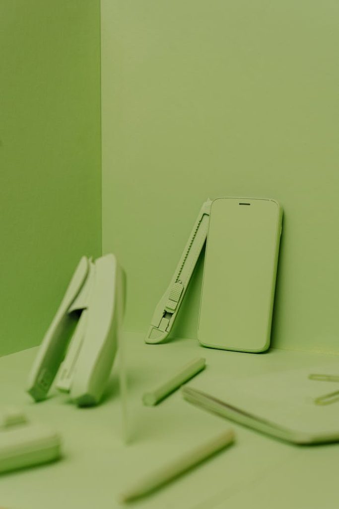 A collection of green office supplies displayed in a minimalistic style. Perfect for design and organization concepts.
